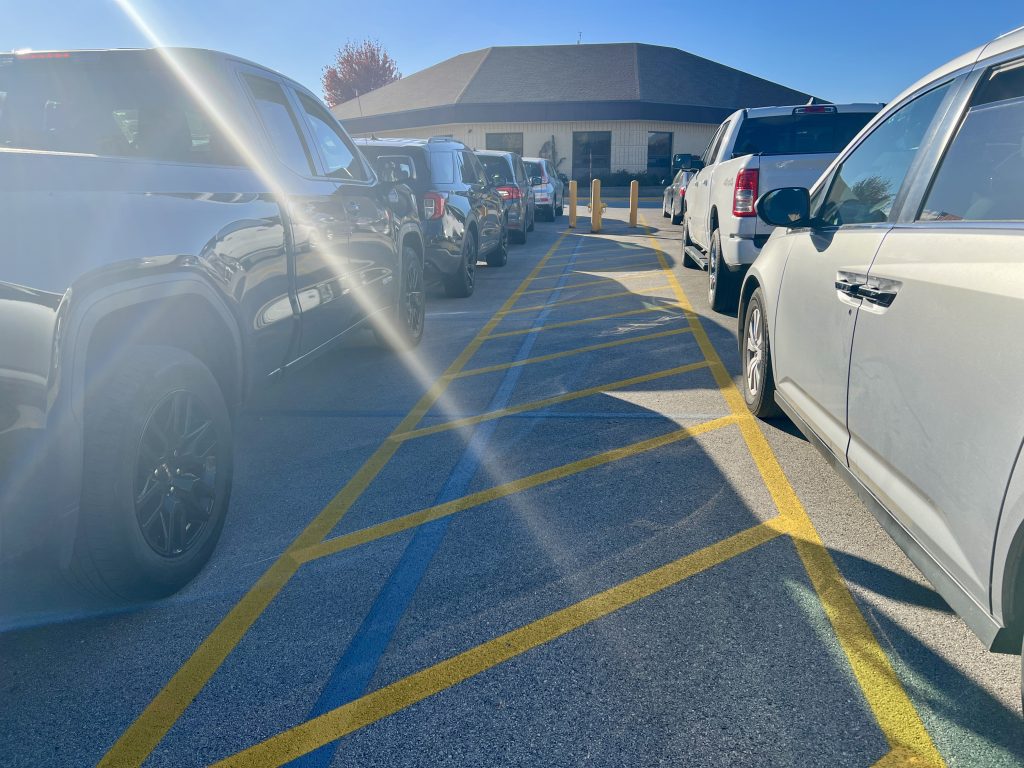 between two aisles of waiting cars