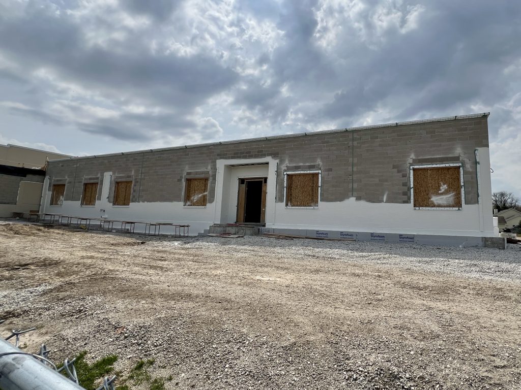 exterior of unfinished Lannon addition. exposed brick, boarded up windows. open area where door will go. April 28, 2025