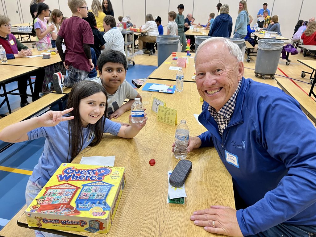Senior Volunteer with two students smiling.