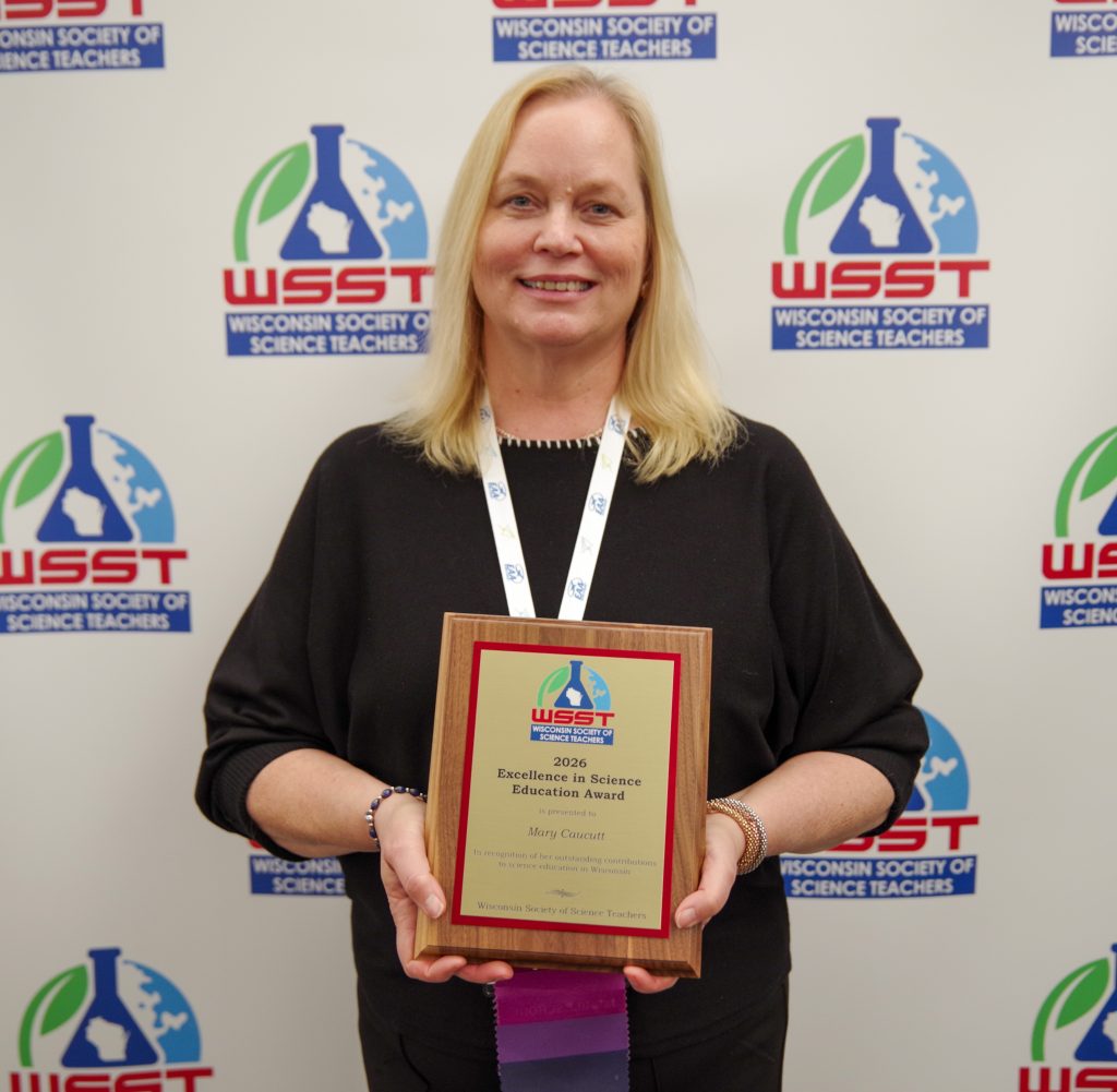 Teacher holding an award plaque.