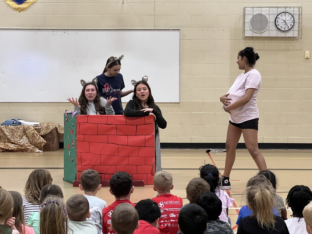 Middle School students performing a skit in front of elementary school children